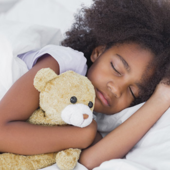 Snoring little girl in bed with green sheets